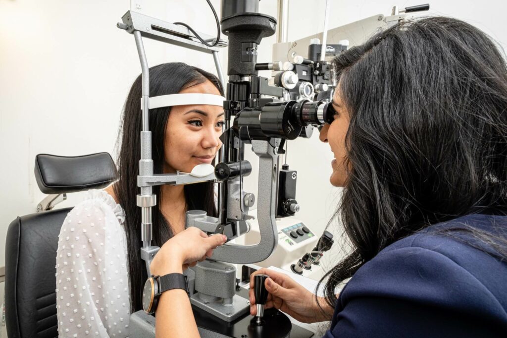 Optometrist talking with a patient during eye exam